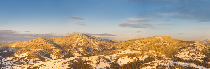 Golden Sunset Over Snowy Mountain Peaks in Winter