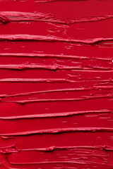 Abstract texture background of a vibrant red lipstick smear.