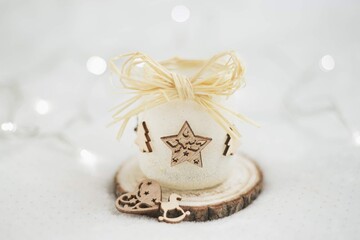 Handmade frosted candle holder with wooden star and heart ornaments on white background