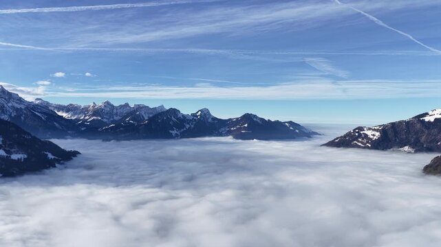 Churfirsten alps, Walensee, Amden, Switzerland aerial drone view above sea of clouds, vast alpine horizon and calm winter atmosphere.