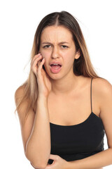Fototapeta premium Studio shot of a natural woman with long dark hair wearing a black top, touching her cheek with painful expression, portrait on a white background