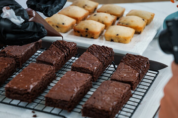 chocolate sauce decorating on many chocolate brownies in baking tray