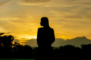 Silhouette of an Asian woman at sunset. Illustration of a lonely woman, an introverted woman. World...