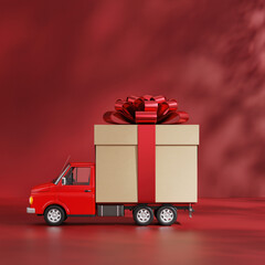 Small red truck carrying a large gift box with a red bow on a plain background in a cozy setting