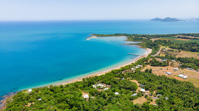 Aerial view of where the turquoise ocean kisses the sandy beach near the lush green vegetation, Mission Beach, Queensland, Australia.
