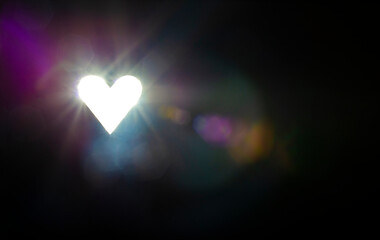 Heart shape sun beam lens optical flare effect on black background
