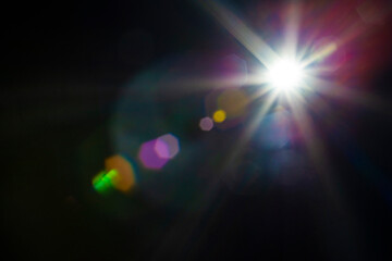 Lens flare and light multi color overlay effect on black background