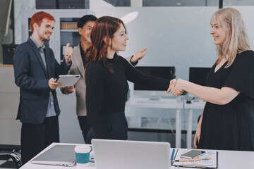 Meeting, partnership and business people shaking hands in the office for a deal, collaboration or onboarding. Diversity, professional and employees with handshake for agreement, welcome or greeting.