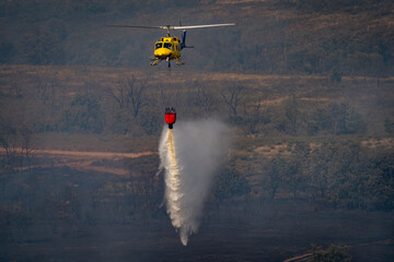 Helicopter Drops Water to Control Forest Wildfire