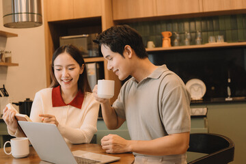 Happy Asian couple enjoying time together in their new home
