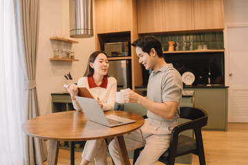 Happy Asian couple enjoying time together in their new home