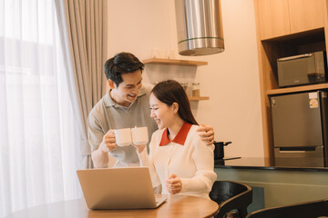 Happy Asian couple enjoying time together in their new home