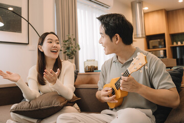 Happy Asian couple enjoying time together in their new home