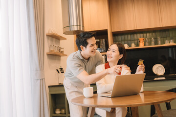 Happy Asian couple enjoying time together in their new home