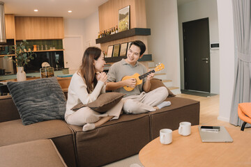 Happy Asian couple enjoying time together in their new home