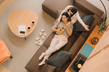 Happy Asian couple enjoying time together in their new home