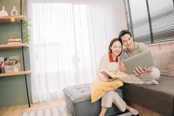 Happy Asian couple enjoying time together in their new home
