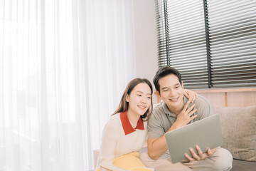 Happy Asian couple enjoying time together in their new home