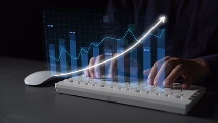 A close-up view of hands typing on a keyboard with a glowing digital graph overlay, emphasizing financial growth trends and data analysis in a modern office setting. Copula