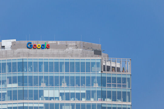 Warsaw, Poland &ndash; August 24, 2024: Google logo displayed on the rooftop of a modern office building with glass facade against a clear blue sky