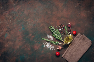 Dark grunge background with cooking ingredients, spices, herbs, and olive oil. Top view, flat lay,...