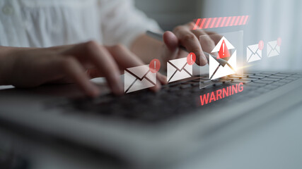 A person typing on a laptop with a visual email warning notification, highlighting the importance of cybersecurity and alertness in digital communication. Gantry