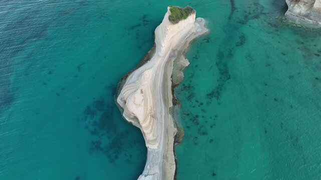 Aerial view of the stunning rock formation in Agios Stefanos, where the pale rock meets the clear turquoise water, creating a mesmerizing contrast, Agios Stefanos, Greece.