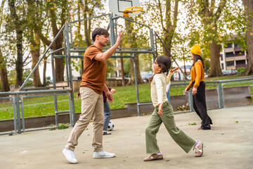 Obraz premium Family father daughter playing basketball outdoors giving high five