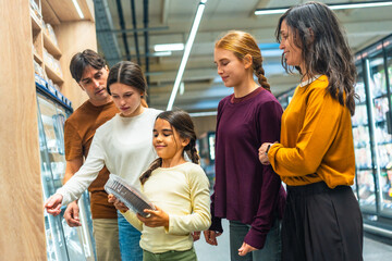 Obraz premium Family shopping for groceries at supermarket with daughters