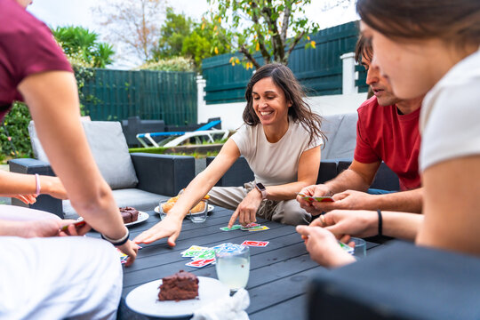 Family playing card game together on patio