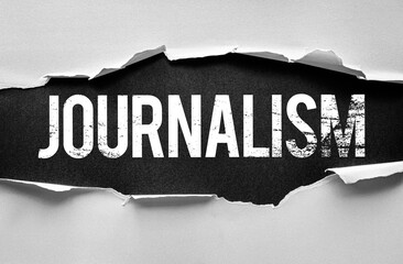 Word JOURNALISM revealed through torn paper. Conceptual image symbolizing the profession of...