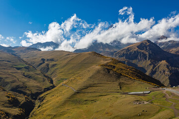 Naklejka premium Sunny Autumn Mountain Landscape With Rolling Hills And Clouds In Georgia