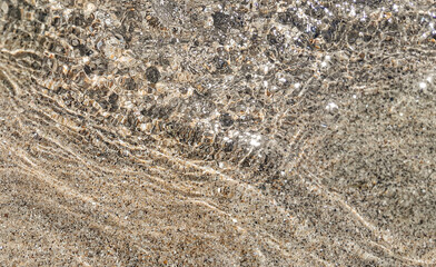 Crystal clear water surface, ripple water in the sea with sun reflection