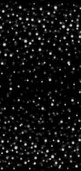 White snow flakes or snowfall on isolated black background. Vertical image 19:9 format for mobile phone screen.