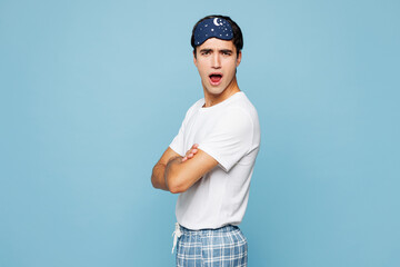 Side view calm young indignant frowning sad mad man he wear pyjamas jam sleep eye mask rest relax at home look camera isolated on plain pastel light blue cyan background. Bad mood night nap concept.