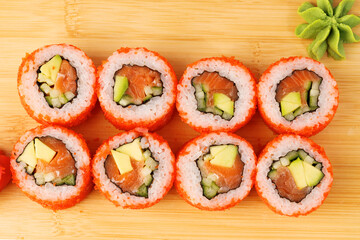 Delicious sushi rolls with fresh ingredients on wooden board