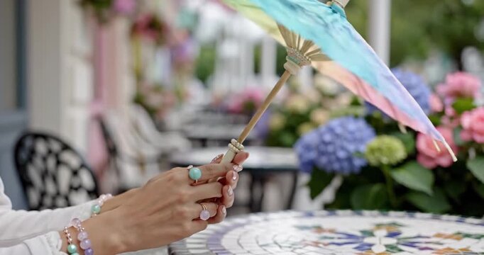 Elegant Woman Holding a Decorative Parasol in a Garden Setting.