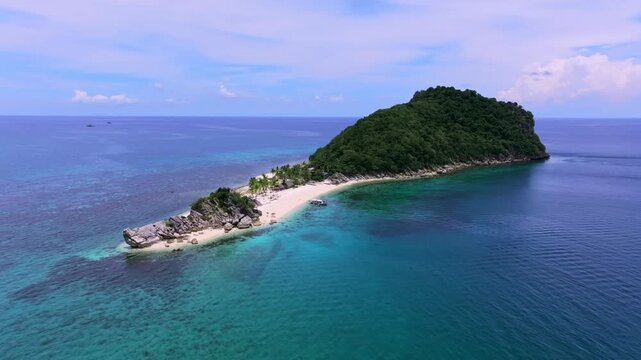 Aerial view of a vibrant tropical island with lush green trees, white sandy beaches and turquoise waters, Carles, Western Visayas, Philippines.