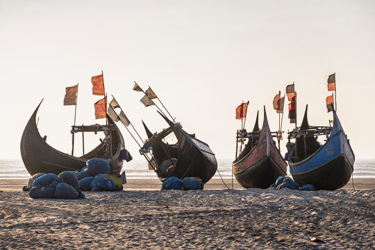 Seascape view before sunset of traditional wooden fishing boats known as moon boats on beach, Cox's Bazar, Bangladesh