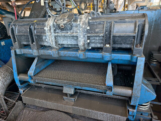 A shale shaker on an oil rig is a vibrating screen that separates large drilled solids, or cuttings, from the drilling fluid, or mud.