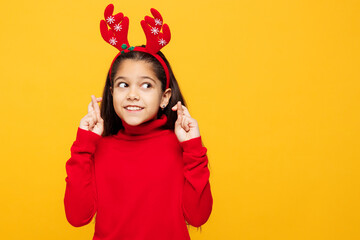 Merry little girl wear red clothes decorative deer horns on head posing wait special moment keep...