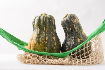 Ripe, yellow-green butternut squash after autumn harvest from an organic farm, on a white background. A healthy cooking ingredient