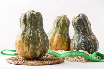 Ripe, yellow-green butternut squash after autumn harvest from an organic farm, on a white background. A healthy cooking ingredient