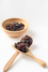 Dried dark raisins on a white background. A healthy snack