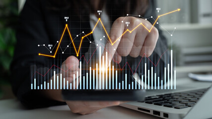 Professional analyzing financial data on smartphone while using laptop, showcasing graphs and growth trends in a modern office setting for insightful business decisions. Scalp