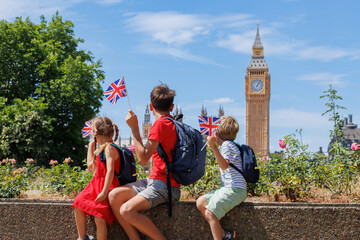 Group of kids looking at Parliament and Big Ben holding flags