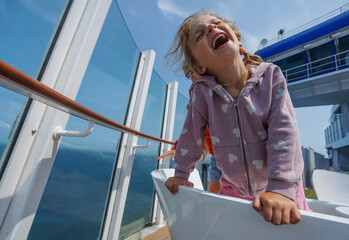 Girl with a big smile is leaning over on ferry crossing channel