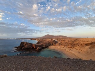 Papagayo Beach, Lanzarote: A stunning beach with golden sand, turquoise waters, and secluded coves. Cloudy sky. Evening time. Lanzarote island