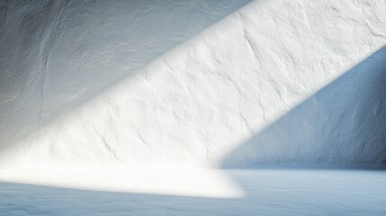 A white wall with a textured surface and a diagonal beam of light.