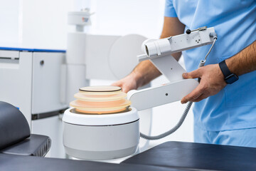 Technician operating diagnostic imaging device. Clinical specialist handling equipment during preparation phase